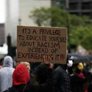 A protester holding a banner saying 